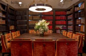 a table in a library with a vase of flowers at Hotel San Antonio el Real in Segovia