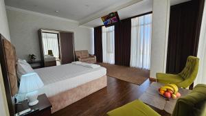 a bedroom with a bed and a table with fruit on it at Grand Turon Plaza Hotel in Tashkent +55 photos