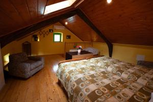 une chambre avec un lit et une chaise dans un grenier dans l'établissement Holiday house Mario, à Peresiji