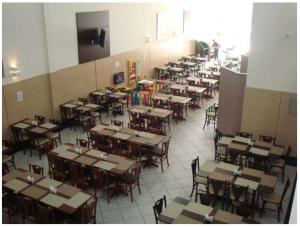 an empty classroom with tables and chairs in a room at Hotel QualitySul in Teixeira de Freitas