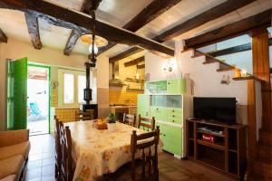 La cuisine est équipée d'une table et d'un réfrigérateur vert. dans l'établissement Holiday house Mario, à Peresiji