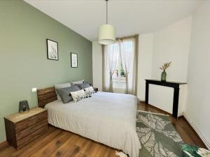a bedroom with a large bed and a window at L'Étoile du Langevin 450m Avenue Champagne in Épernay