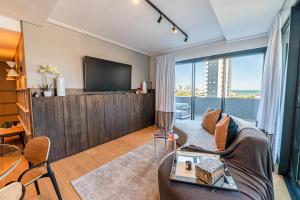 TV a/nebo společenská místnost v ubytování Beachfront Apartment with wrap around terrace in Blouberg, 04 Azul