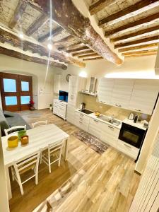 a kitchen with a white table and a table and chairs at La Casa della Campana in Cortona