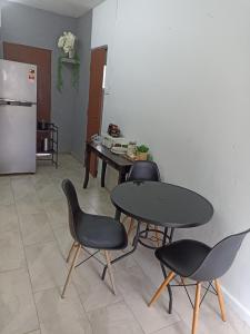 a kitchen with three chairs and a table and a refrigerator at Studio Landed House SS2 Garden View in Petaling Jaya