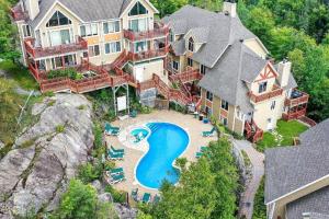 an aerial view of a large house with a swimming pool at Hauts-bois Ski Inout 2brs Wpool Access 197-9 in Mont-Tremblant