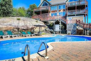 a house with a swimming pool in front of a house at Hauts-bois Ski Inout 2brs Wpool Access 197-9 in Mont-Tremblant +9 photos