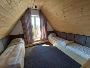 two beds in a room with a window at Willa Maciejka in Trybsz