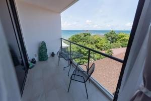 a balcony with chairs and a view of the ocean at Escape condo E166 in Mae Pim