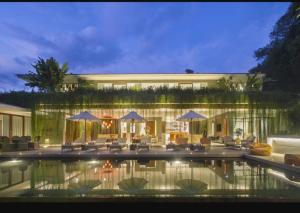 een huis met een zwembad in de nacht bij THE MUSE Pantai Nyanyi Villa in Canggu