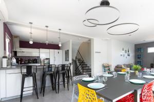 eine Küche und ein Wohnzimmer mit Tisch und Stühlen in der Unterkunft Villa 250m Spa privé, Borne d'arcade, Babyfoot - Gite des frères-Strasbourg in Hurtigheim