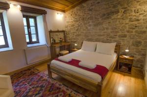 a bedroom with a bed and a stone wall at Goldsmith House in Selçuk