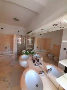 a bathroom with two sinks and a toilet and a tub at Sweet House in Solesino