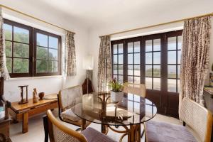 a dining room with a glass table and chairs at Alto da Praia Villa in Colares
