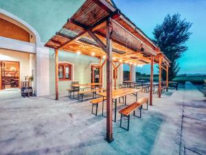 a pavilion with wooden tables and benches on a patio at CORTE DELLA BIRRA - OLDO in Cadelbosco di Sopra