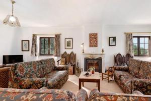 a living room with couches and a fireplace at Alto da Praia Villa in Colares