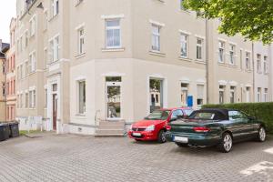 zwei Autos vor einem Gebäude geparkt in der Unterkunft Doppelzimmer III Gästezimmer in Unterkunft mit Gemeinschaftsbad und Gemeinschaftsküche Chemnitz in Chemnitz