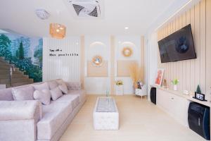 Una sala de estar con un sofá y un televisor. en Tiara PoolVilla Pattaya Bang Saray Beach 1 km, en Bang Sare