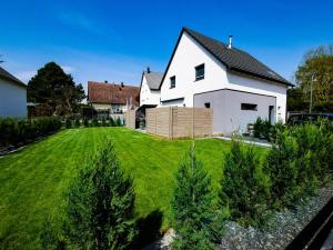 ein weißes Haus mit einem Garten voller Weihnachtsbäume in der Unterkunft Villa 250m Spa privé, Borne d'arcade, Babyfoot - Gite des frères-Strasbourg in Hurtigheim