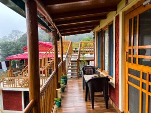 a balcony of a house with a table and chairs at Odyssey Stays Sathkol in Mukteshwar