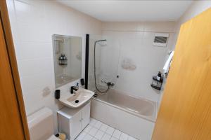 a white bathroom with a sink and a shower at Charmant studio à côté des pistes de ski in Nendaz +9 photos