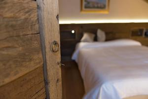 a bed in a room with a wooden wall at La Vigne de Papagran in Aosta