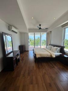ein großes Schlafzimmer mit einem Bett und einem TV in der Unterkunft Nilaveli Condos by Amba in Nilaveli