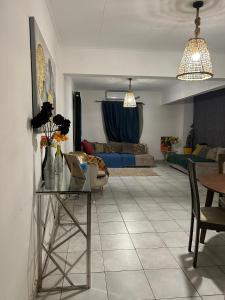 a living room with a table and a couch at Le Nid Douillet de Cécilia in Libreville +5 photos