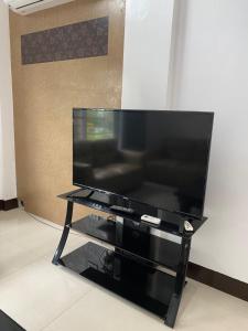 a large flat screen tv sitting on a black stand at Rio Grande de Pampanga Villas in Fort Stotsenburg
