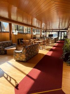 a lobby with tables and chairs in a building at Il Cirmolo delle Saline in Falcade