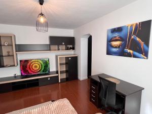 a living room with a television and a desk at Central Apartment in Turnu Măgurele