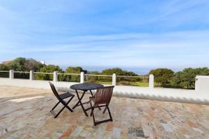 a table and two chairs sitting on a patio at Alto da Praia Villa in Colares