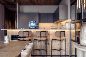 a kitchen with a wooden counter with stools at Antarès SIRIUS 201 - Prestigious ski inski out apartment in Méribel