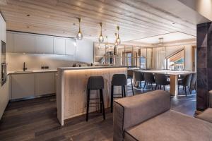 a kitchen with a bar with chairs and a table at Antarès SIRIUS 503 - Spacious ski inski out apartment in Méribel