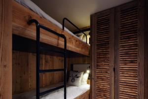 a bunk bed in a room with wooden walls at Antarès SIRIUS 301- Spacious ski inski out apartment in Méribel