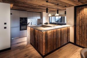 a kitchen with a large wooden island in the middle at Antarès SIRIUS 302 - Ski inski out family apartment in Méribel