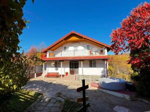a white house with a red roof at Casa NIB Calimanesti in Călimăneşti