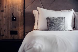 a bed with white sheets and a pillow at Antarès SIRIUS 304 - Spacious ski inski out family apartment in Méribel +1 photo