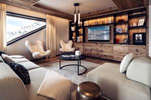 a living room with a couch and a tv at Antarès SIRIUS 304 - Spacious ski inski out family apartment in Méribel