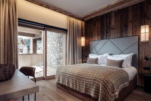 a bedroom with a large bed and a balcony at Antarès SIRIUS 201 - Prestigious ski inski out apartment in Méribel +23 photos