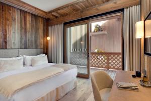 una camera d'albergo con un letto, una scrivania e una finestra di Antarès NAOS 201 - luxury apartment ski inski out a Méribel
