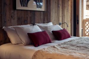 a bed with four pillows on it in a bedroom at Antarès URSA 402 - luxury apartment ski inski out in Méribel