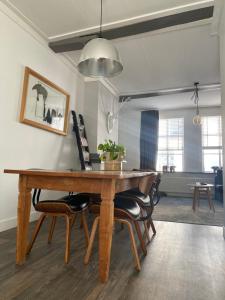 a dining room with a wooden table and chairs at Historical loft in Middelburg