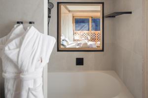 a robe hanging in a bathroom with a mirror at Antarès SIRIUS 503 - Spacious ski inski out apartment in Méribel