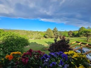 un giardino con fiori colorati e una panca di legno di Tinkuy a Molinari