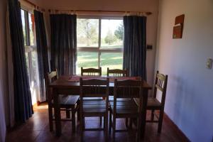 una sala da pranzo con tavolo, sedie e una finestra di Tinkuy a Molinari