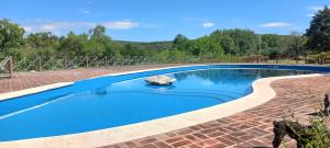 una piscina con acqua blu in un cortile di mattoni di Tinkuy a Molinari
