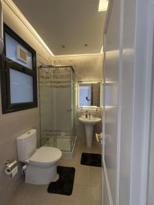 a bathroom with a toilet and a shower and a sink at Celia -1 Bedroom Beauty in Madīnat al Amal +34 photos