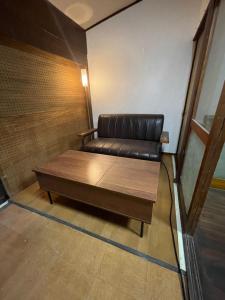 a brown leather couch in a room at 懐かしい日本の家 nostalgic Japanese house For-R Uwamachi Share House in Yokosuka
