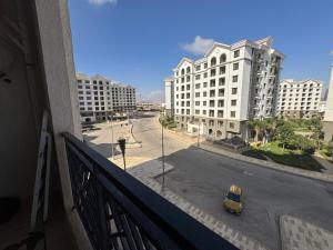 a yellow car is parked on a street with buildings at Celia -1 Bedroom Beauty in Madīnat al Amal